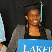 masters student with foam finger and Laker for a Lifetime sign